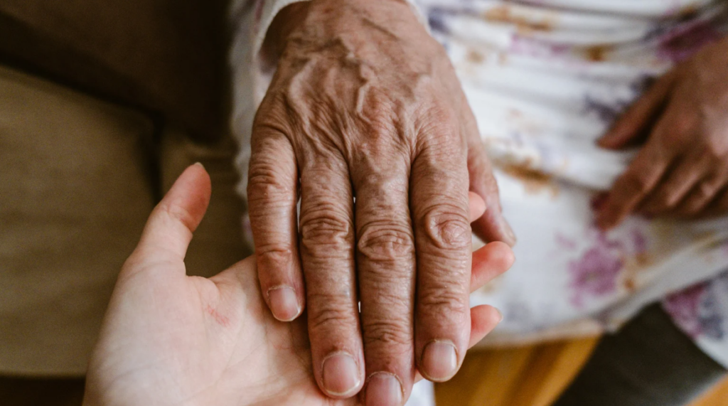Caregiver assisting an older adult while exploring ways to pay for long-term care during retirement.