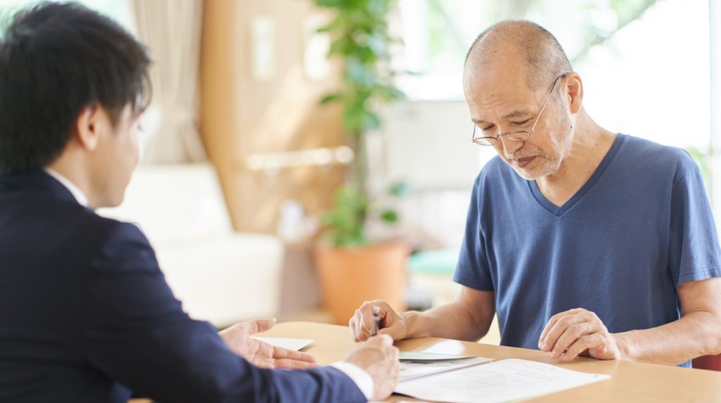 Long-term care planning discussion between an older couple and their financial advisor about retirement healthcare costs.